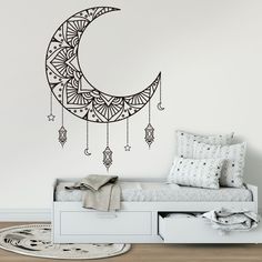 the moon and stars wall decal is shown in black on a white wall above a daybed