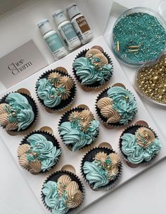 cupcakes with blue frosting and gold sprinkles on a tray