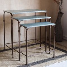 three metal nesting tables sitting on top of a rug