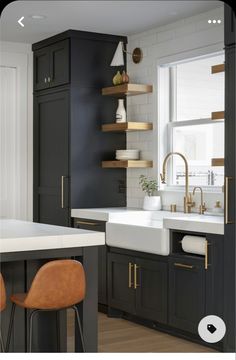 a kitchen with black cabinets, white counter tops and wooden stools in front of the sink