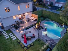 an aerial view of a backyard with a swimming pool and patio area at night time