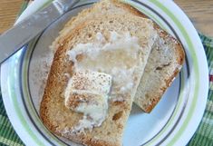 two slices of bread on a plate with butter