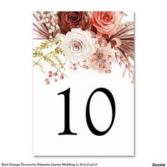 a table number with flowers on it and the number ten in red, white and pink