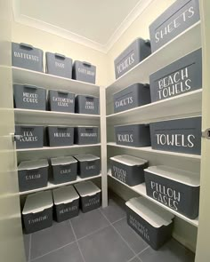 a walk in closet filled with lots of boxes and bins on the shelves next to each other