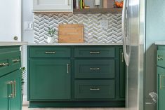 a kitchen with green cabinets and white walls