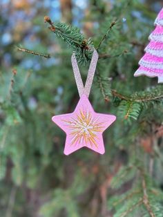 a pink ornament hanging from a tree