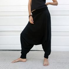 "Black Samurai Style Ninja Pants for Women and Men. This Stretch Cotton Harem Pants Fit Plus Size. -Unisex -Stretch -Flowing relaxed fit -Inner drawstring to secure the waist -2 side pockets Great for Yoga, Dance, Exercises, Meditations, Yoga Practice and beyond... Materials: black color cotton blend (90% cotton 10% lycra). Fabric for this pair were bought in Fashion District, LA and the pant was made in one of the studios in Los Angeles, CA. Measurements: Fits: S, M, M/L -Length: 41\" (~102 cm) Black Hip-length Bottoms For Yoga, Black Wide Leg Harem Pants For Loungewear, Black Relaxed Fit Harem Pants For Loungewear, Black Baggy Hip-length Bottoms, Black Cotton Harem Bottoms, Black Stretch Harem Pants For Loungewear, Stretch Black Harem Pants For Loungewear, Black Wide Leg Sweatpants For Yoga, Black Wide-leg Sweatpants For Yoga