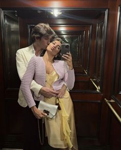 a man and woman are taking a selfie in the elevator while holding their cell phone