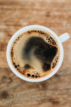 a cup of coffee on top of a wooden table