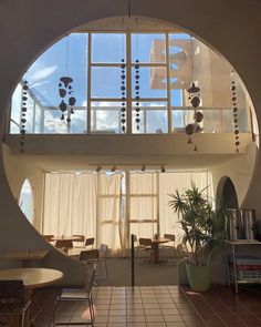 the inside of a building with an arched window and white curtains on the windowsill