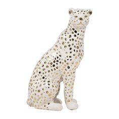 a ceramic white and gold spotted cheetah figurine sitting on the ground