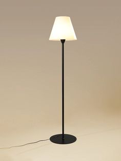 a black floor lamp with a white light on it's side and a cord plugged into the base