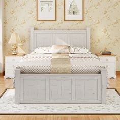 a white bed sitting on top of a wooden floor next to two pictures above it