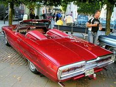 an old red car parked on the street