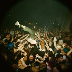 a man on top of a crowd at a concert