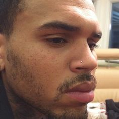 a close up of a man with piercings on his nose