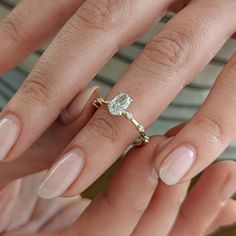 a woman's hand with two engagement rings on her fingers, and the other hand holding an engagement ring