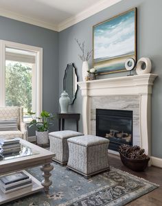 a living room filled with furniture and a fire place in front of a painting on the wall