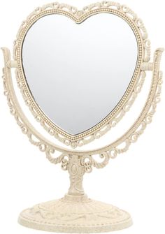 a heart shaped mirror sitting on top of a white stand with an ornate design around it