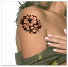 a woman's shoulder with flowers on it and an arm tattoo in the shape of a flower