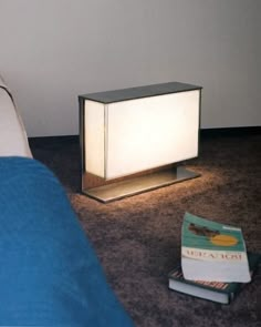 a lamp sitting on the floor next to a book