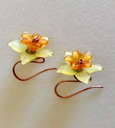 "Darling lightweight yellow daffodils with orange centers dangle on handmade natural copper hooks of 20 gauge German copper wire. Delicate lucite daffodil flower measures 20 mm wide and is embellished with bright orange lucite center flower and tiny lacey copper bead caps. Total length is 1\". Darling springtime accessory!" Orange Daffodils, Lucite Flowers, Bright Copper, Daffodil Flower, Yellow Daffodils, Flowers Handmade, Earrings Flower