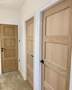 two wooden doors in an empty room with carpet