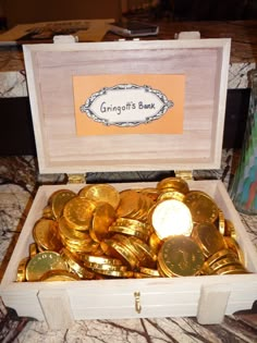 a wooden box filled with lots of gold coins