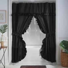 a black curtain with ruffles hanging from it's side in front of a window