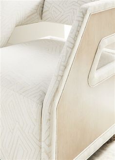 an upholstered bed with white linens on it