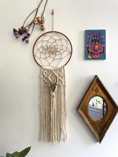 a wall hanging with a dream catcher next to a mirror and other items on the wall