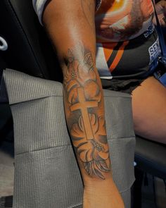 a man with a cross tattoo on his arm