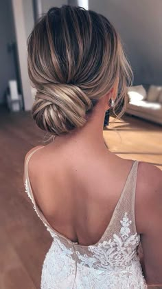 the back of a woman's head, wearing a wedding dress with an intricate braid