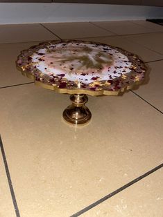 a cake plate sitting on top of a tiled floor