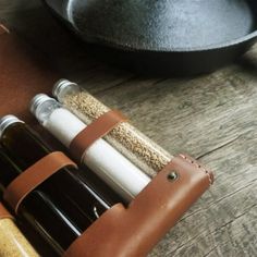 a leather case holds four bottles and a frying pan