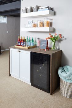 a bar with liquor bottles and flowers on the counter in a living room or dining room