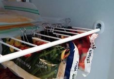 an open refrigerator door with some bags and food on the rack in it's corner