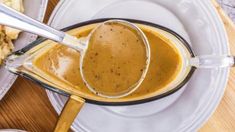 there is a spoon that is in a bowl on the plate with food and utensils