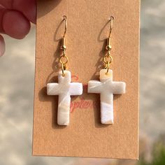 a pair of earrings with a cross on it