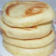 three pancakes stacked on top of each other on a white plate with pink doily