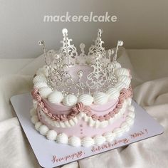 a pink and white cake with a tiara on top