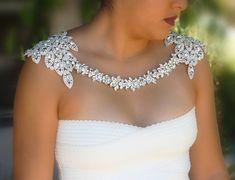 a woman in a white dress wearing an elaborate necklace