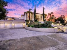 a large house that is in the middle of a driveway with stairs leading up to it