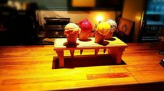 three ice cream cones sitting on top of a wooden table in front of a fireplace