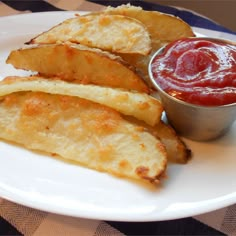 some french fries and ketchup on a plate with a checkered table cloth