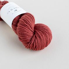 a skein of red yarn sitting on top of a white surface