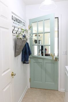 a blue door and some towels hanging on the wall in a room with white walls