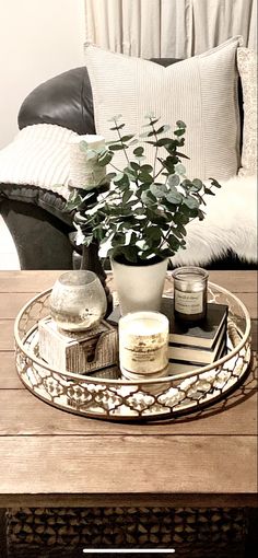 a tray with books, candles and a potted plant sitting on top of it