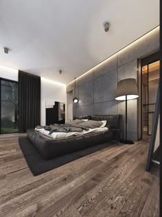 a large bed sitting on top of a wooden floor next to a wall mounted tv