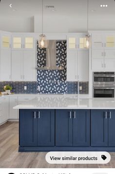 a large kitchen with white cabinets and blue counter tops, along with an island in the middle